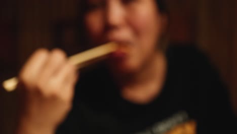 person eating gyoza with chopsticks in bangkok
