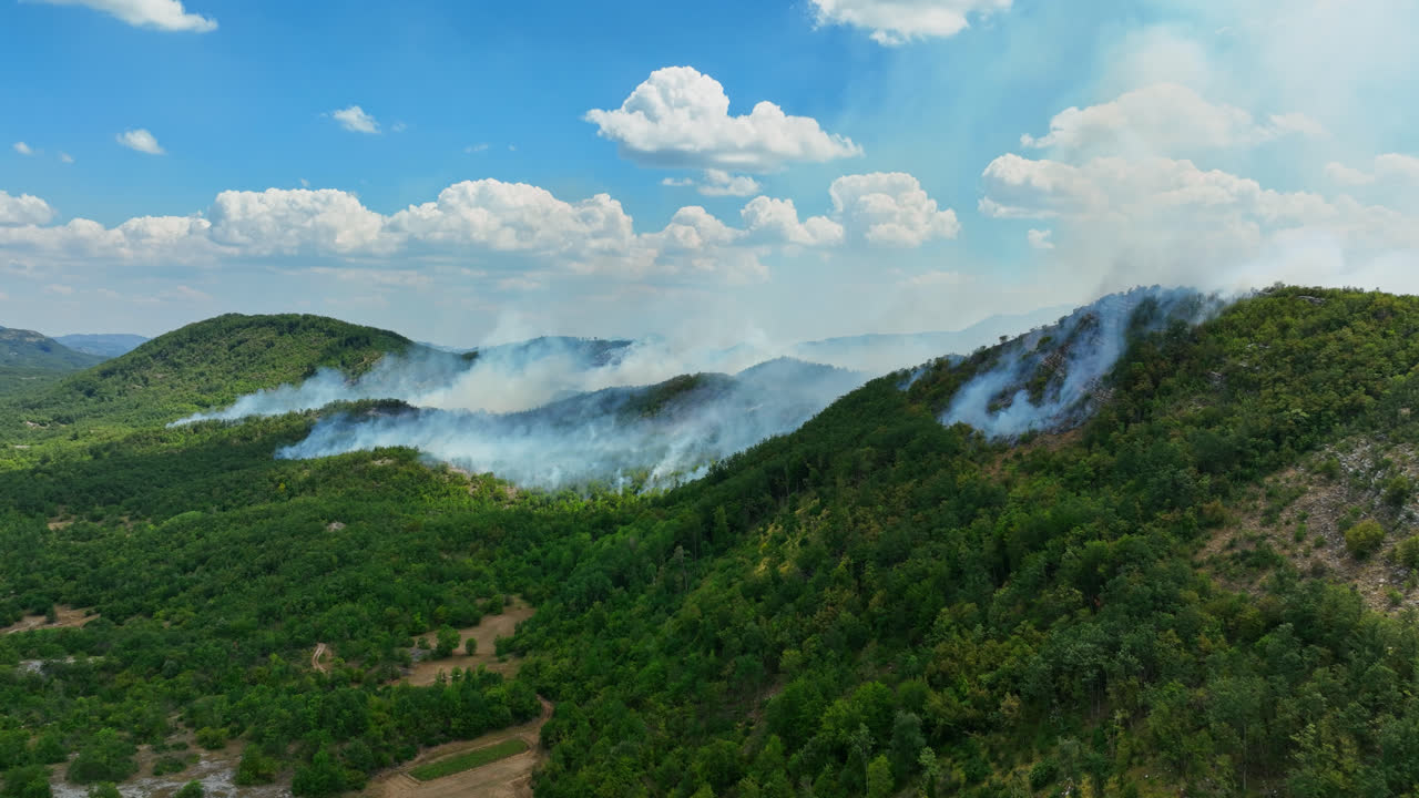 AERIAL: Smoking hills and burning forest in the mountains of sunny, south Europe