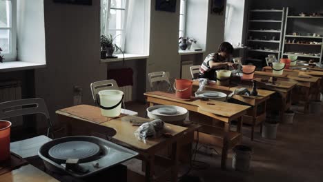 a young man works in a pottery workshop.