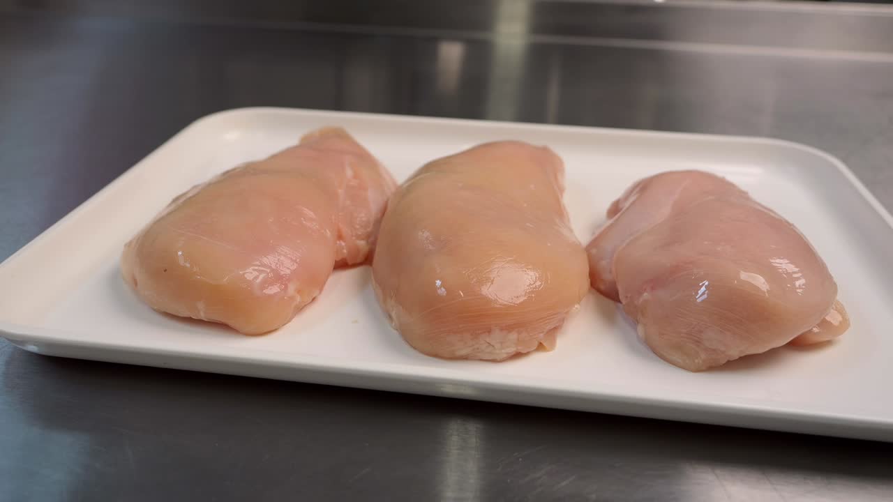 los filetes de pollo frescos se encuentran en una bandeja listos para su posterior procesamiento