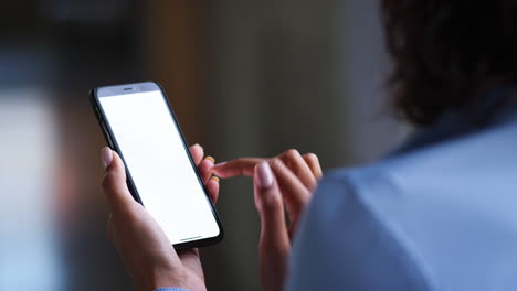 young businesswoman using smartphone touchscreen, back view