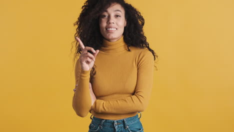 african american confident woman over orange background.