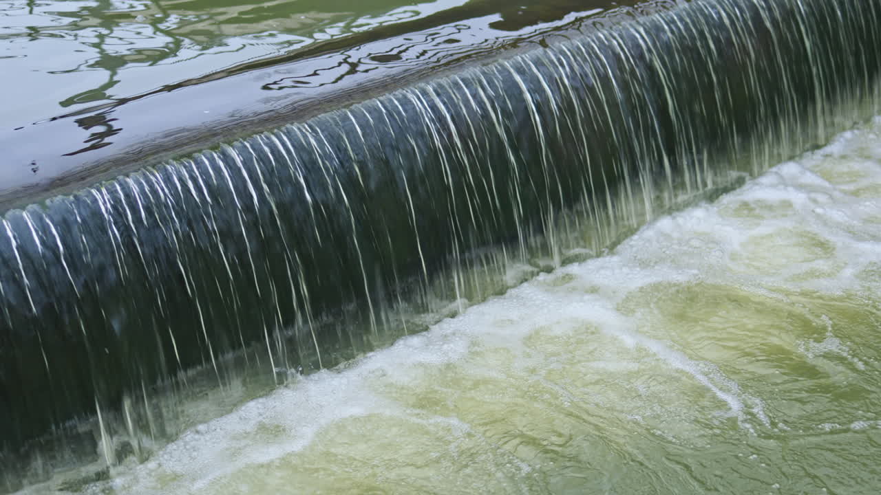 Rio fluindo sobre pedras. Água caindo de uma cachoeira. Água verde no rio