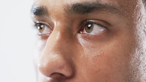 close-up of a young biracial man's eyes on a white background