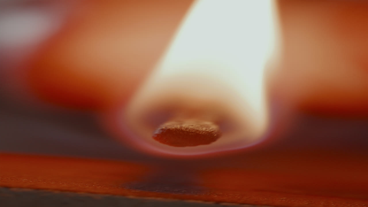 Close-Up of Striking Matchstick against Box Edge and Igniting Flame