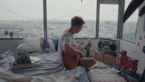 man playing the guitar in bedroom