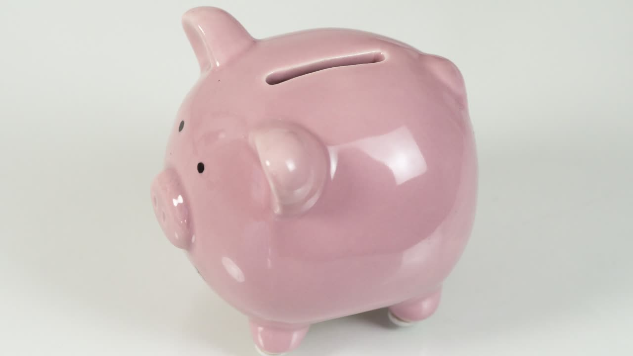 poner monedas a mano en una alcancía, el concepto de ahorrar dinero