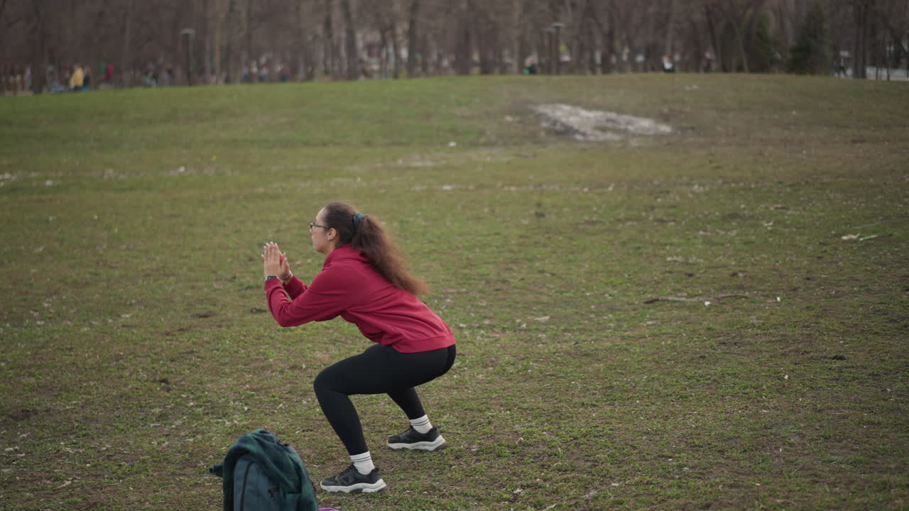 Active Outdoor Exercise, Female Performing Vigorous Exercise And Clapping Drills In Open Space, Energetic Young Woman In Red Hoodie Practicing Dynamic Warmups On Cloudy Day In Open Field
