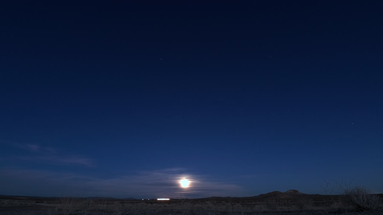 The moon rising from the horizon and illuminating the land - Time lapse