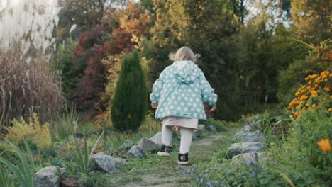 Cute-little-girl-walking-in-the-park.-Back-view,-follow-shot