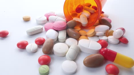 assorted pills and capsules on white background