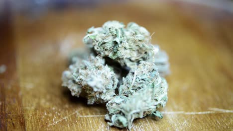 primer plano giratorio flor de marihuana cultivada orgánicamente placa de madera