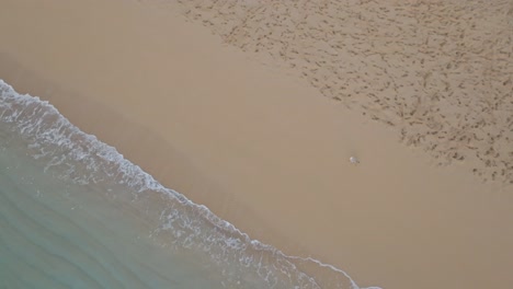 Astounding-top-view-of-waves-crashing-onto-shore-at-Cala-Pregonda-Beach