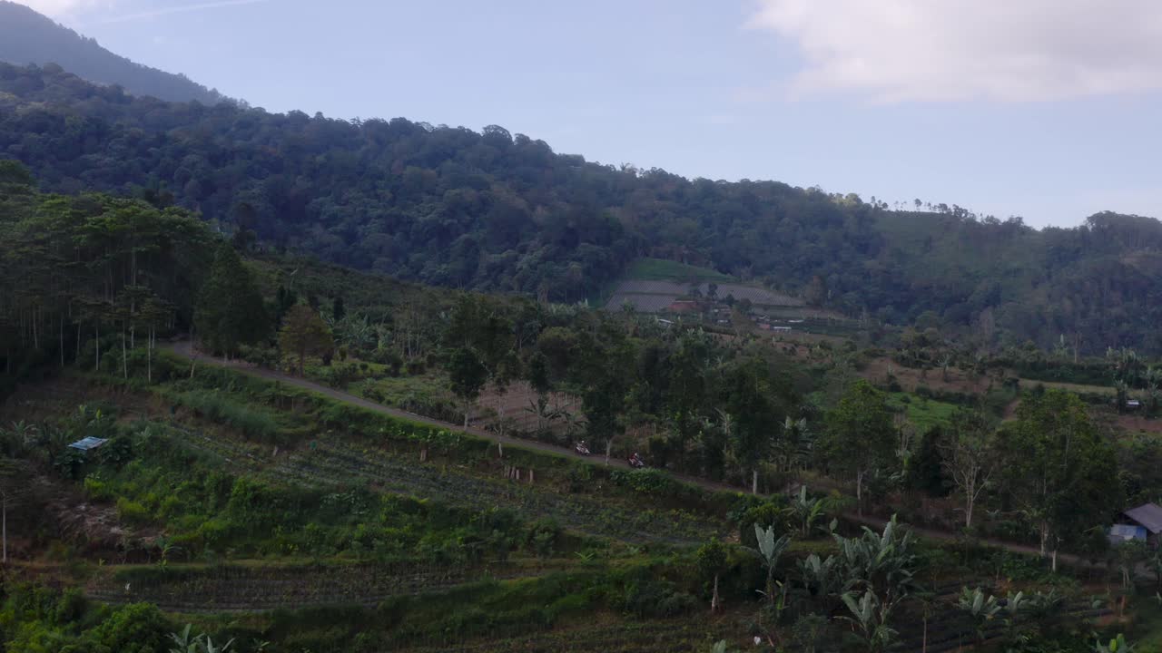 dos personas montando scooters a través de caminos rurales en las tierras altas del sudeste asiático