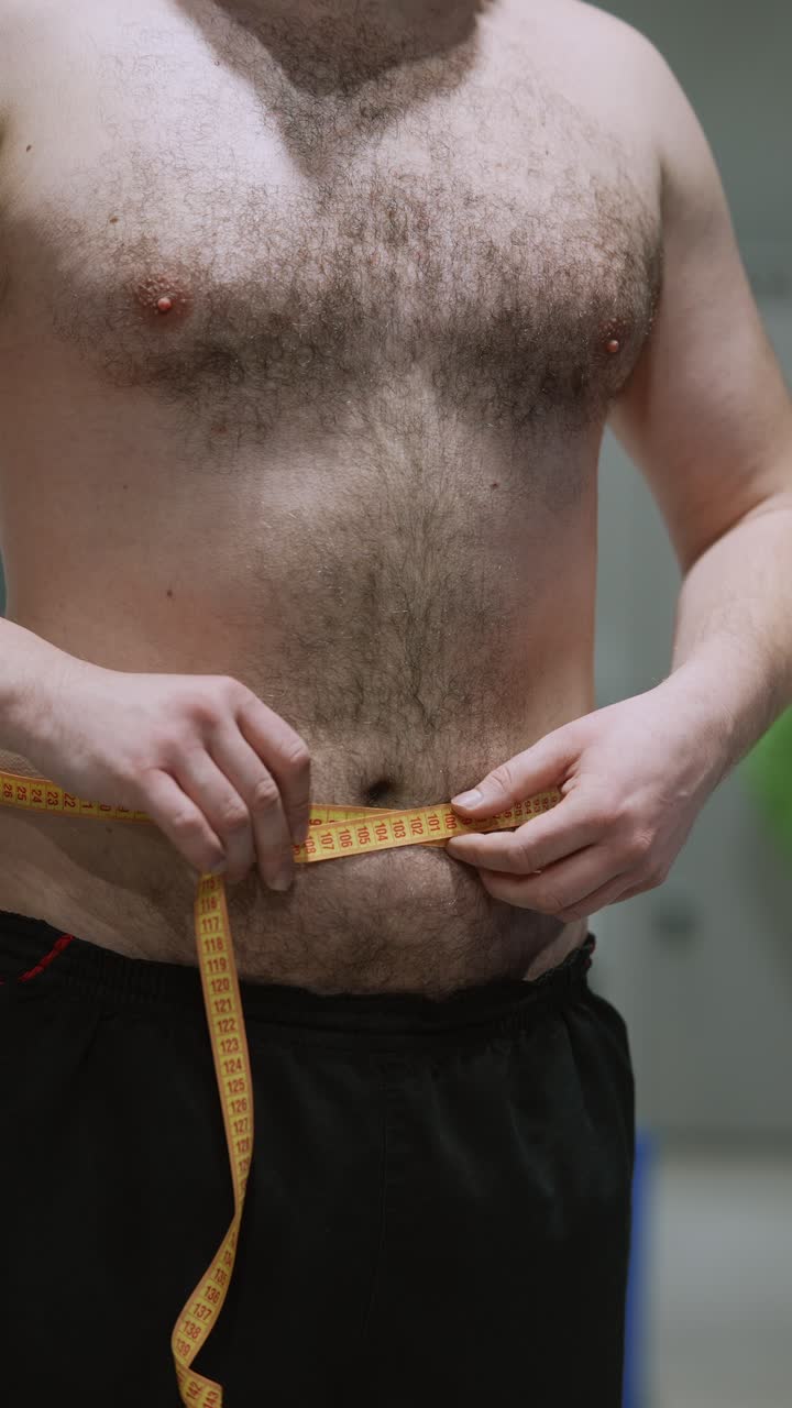 hombre midiendo su cintura con una cinta métrica