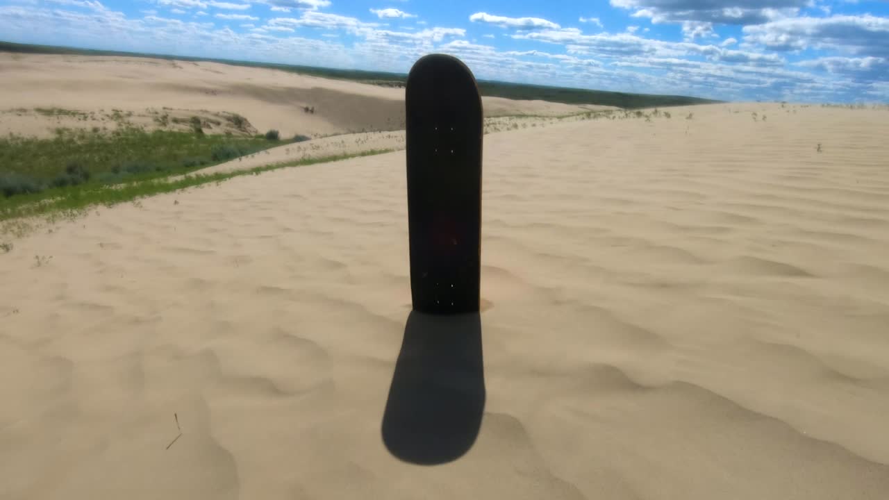 Skateboard deck standing in the sand in the sand dunes on a sunny day near Alberta Canada