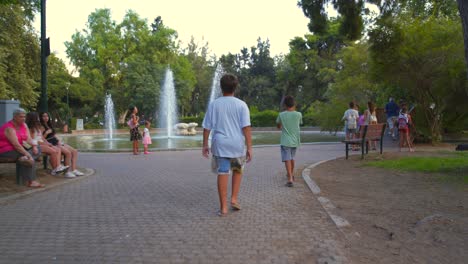people enjoying a sunny day in a park with fountains