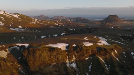 Vista-Aérea-Del-Paisaje-De-Picos-De-Montaña-Con-Nieve-Derretida,-En-Islandia,-Al-Atardecer