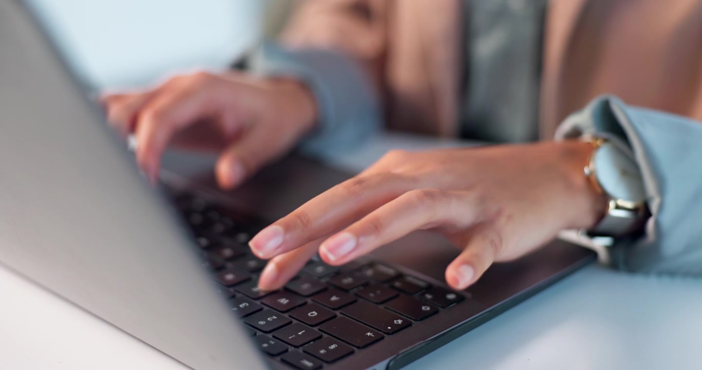 Primo piano di una persona che digita sulla tastiera di un laptop