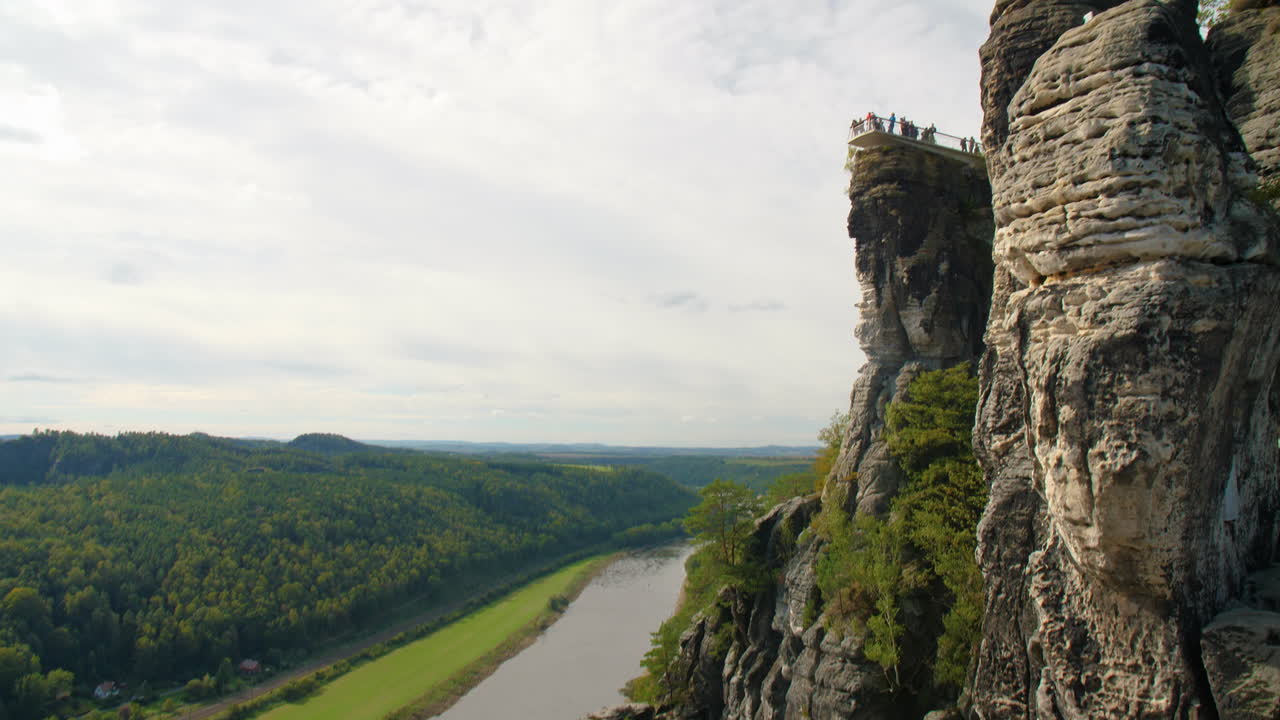 Elbsandsteingebirge Elbe Sachsen with observation deck sandstone formations rising above dense green forests Mountains, natural beauty and rugged Terrain under a blue sky with scattered Clouds
