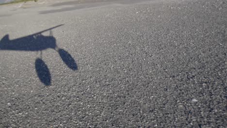 shadow of small civil airplane taking off on rural runway, passenger pov