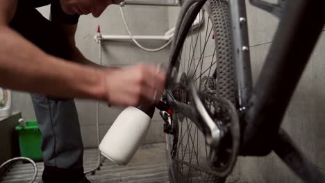 anonymous male mechanic washing bicycle fork