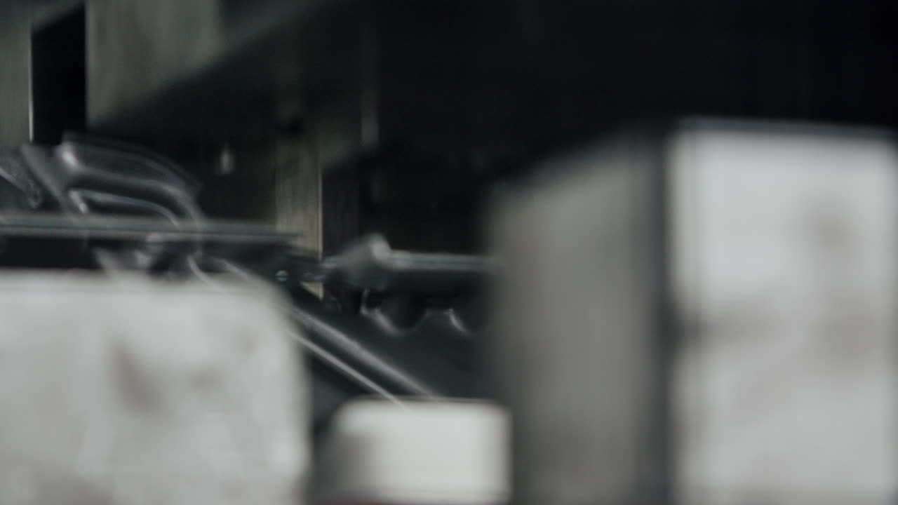 близкое изображение большой гидравлической металлической машины для формования деталей, берущей продукт и прессующей его в форму в замедленном движении