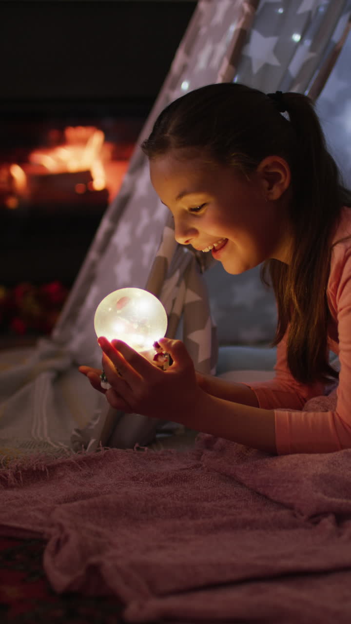 스노우 글로브를 가진 행복한 백인 소녀의 수직 비디오