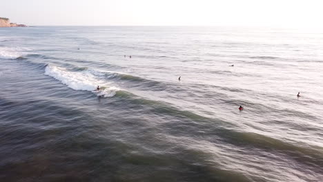 surfeando en la playa de olón, ecuador - turistas divirtiéndose montando olas oceánicas