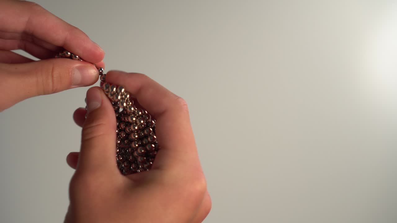 el niño recoge con sus manos un rompecabezas magnético