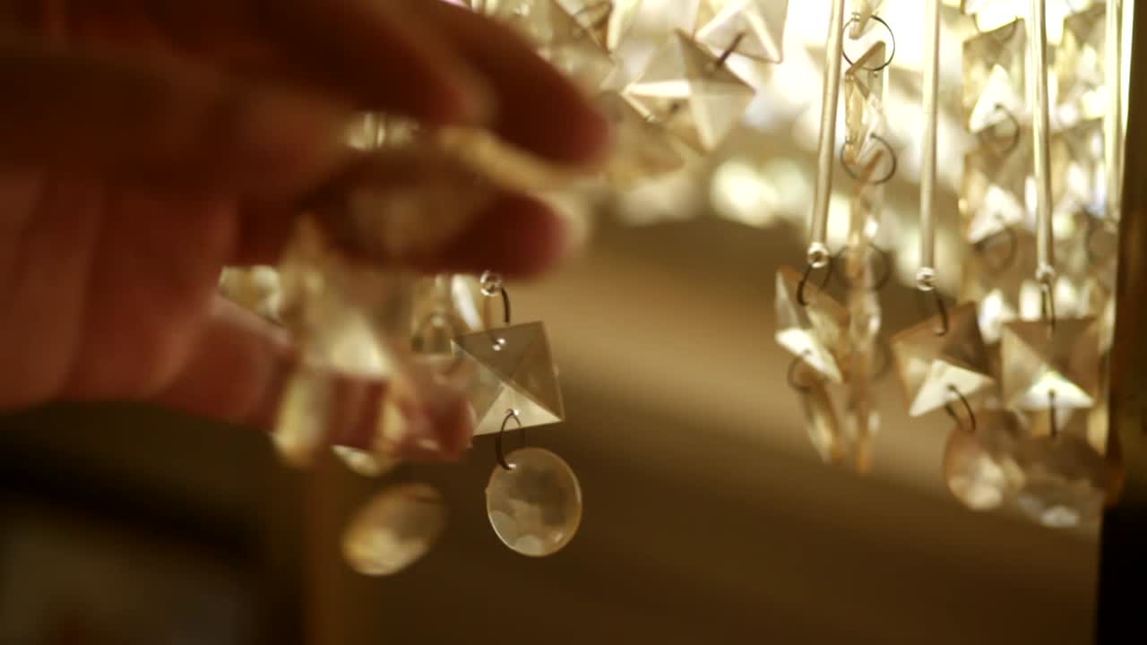 mano femenina negra jugando con candelabro de cristal