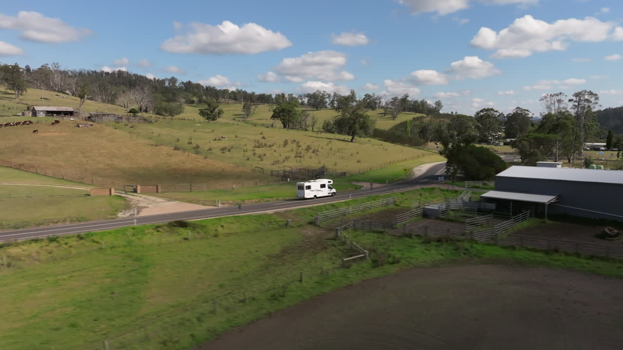 vista aérea de una furgoneta que conduce por una carretera rural en el campo de australia durante un día soleado