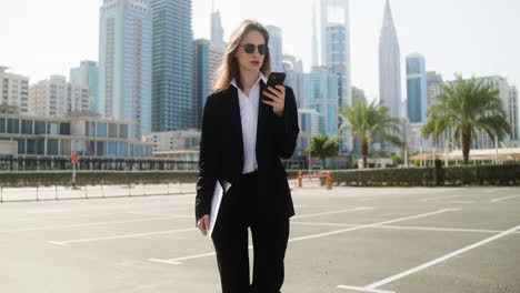 elegant businesswoman with phone outdoors