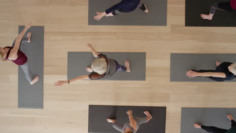 vista superior instructor de clase de yoga enseñando a mujeres maduras practicando pose de guerrero disfrutando de un estilo de vida saludable en el gimnasio