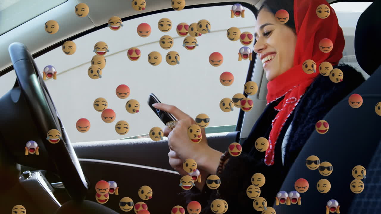 animación de emojis que caen sobre una mujer con hijab usando un teléfono inteligente