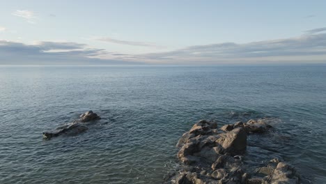 aerial drone view of blue sea of arenys de mar, catalonia, water calm waves and skyline, barcelona spain during summer