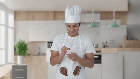 feliz chef profesional indio anotando la receta