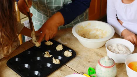 Siblings-preparing-cookie-with-grandmother-in-kitchen-4k