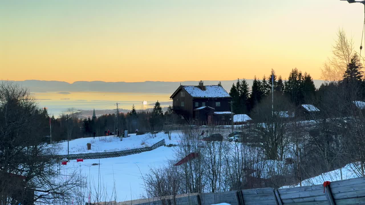Inner Oslo Fjord sunset Norway Norge aerial drone Norwegian Frognersteteren restaurant cabin lodge Skimore Oslo Holmenkollen Ski Jump Cross Country Ski resort winter sunset forest pan left motion