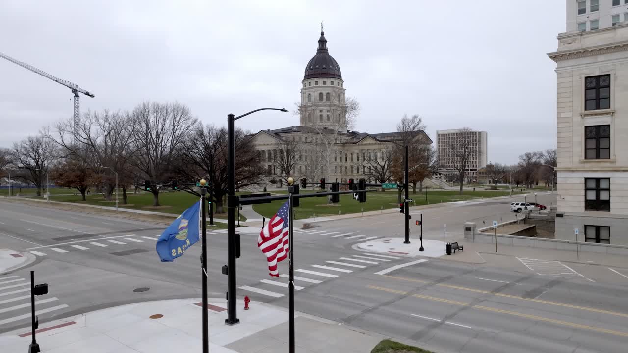 Kansas' delstatshovedstadbygning med flag, der blafrer i vinden i Topeka, Kansas, med stabil dronevideo