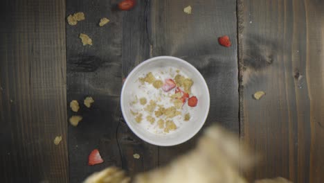 unique view of cereal falling into a bowl of milk