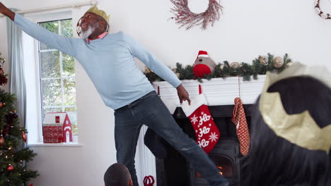 multi generation family playing game of charades as they celebrate christmas at home together