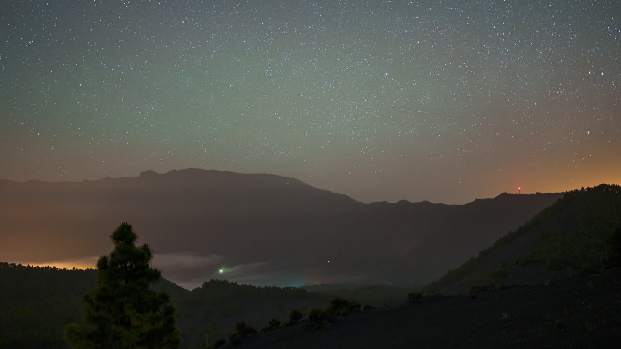A serene view of the starry sky and mountains at Mirador Llano de Jable, La Palma, day to night timelapse