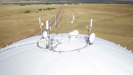Drone-view-of-cellular-signal-transmission-equipment-with-plains-in-the-background