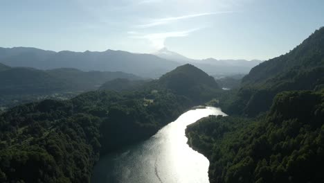 vista aérea do lago el leon com o vulcão villarrica ao fundo em um dia ensolarado - tiro de drone