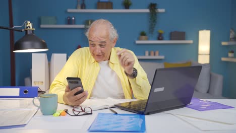 Home-Office-Arbeiter-Alter-Mann-Jubelt-Am-Telefon.