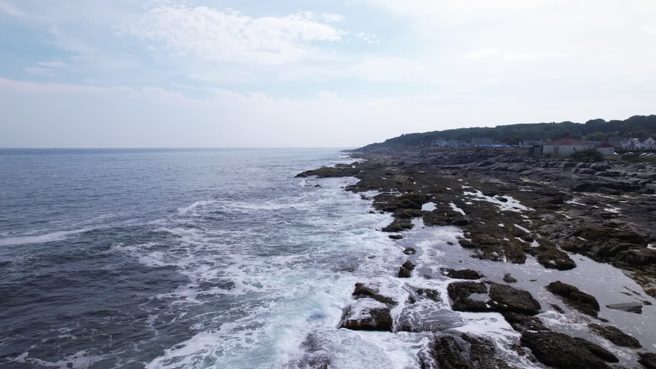 low altitude over tidal water and rocky bluffs on the coastline of southern Maine on Cape Elizabeth