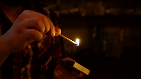 un hombre enciende un fósforo