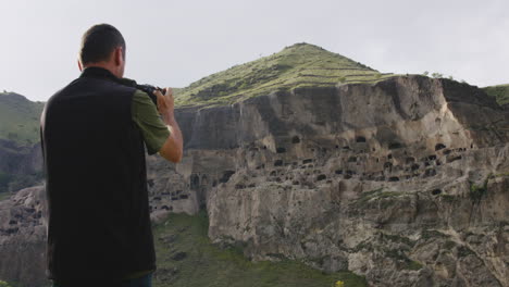 Man-with-professional-camera-taking-photos-of-Vardzia-cave-monastery