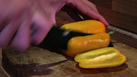 chef masculino cortando un pimiento amarillo fresco